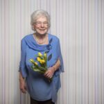 senior-woman-stands-with-tulip-flowers-spring-positive-charisma-against-fear-corona-covid-19